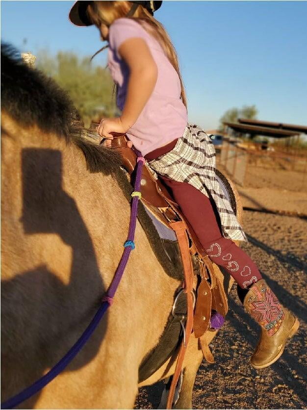 A girl learns to dismount a horse in Legend Acres virtual horse lessons